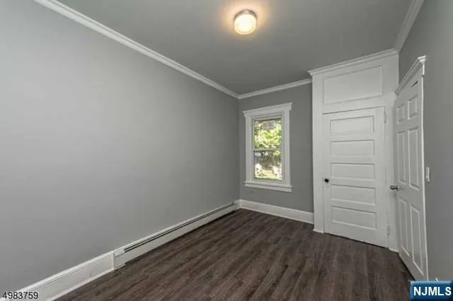 an empty room with wooden floor and window