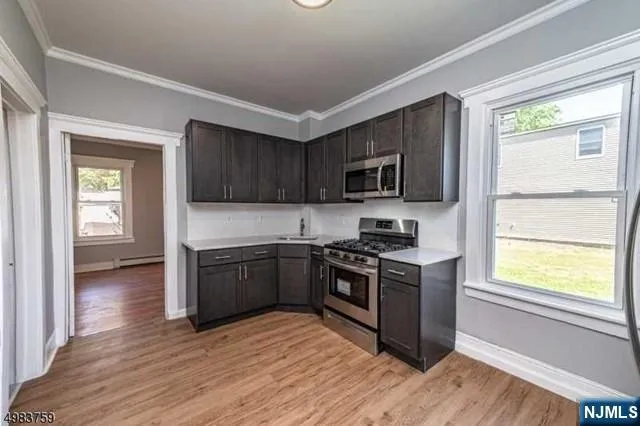 a kitchen with granite countertop wooden floors and stainless steel appliances