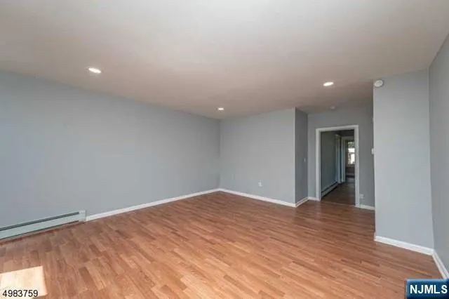a view of an empty room with wooden floor