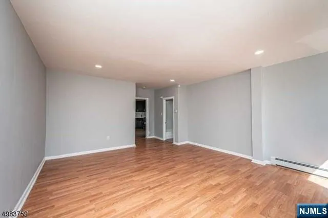 a view of an empty room with wooden floor