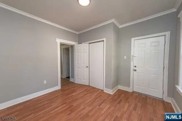 a view of an empty room with wooden floor
