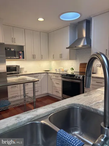 a kitchen with stainless steel appliances granite countertop a sink a stove and a microwave