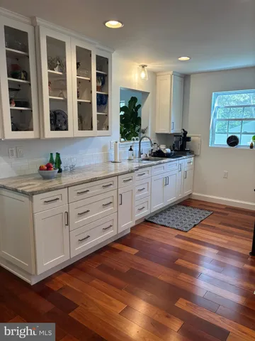 a kitchen with granite countertop white cabinets and white appliances