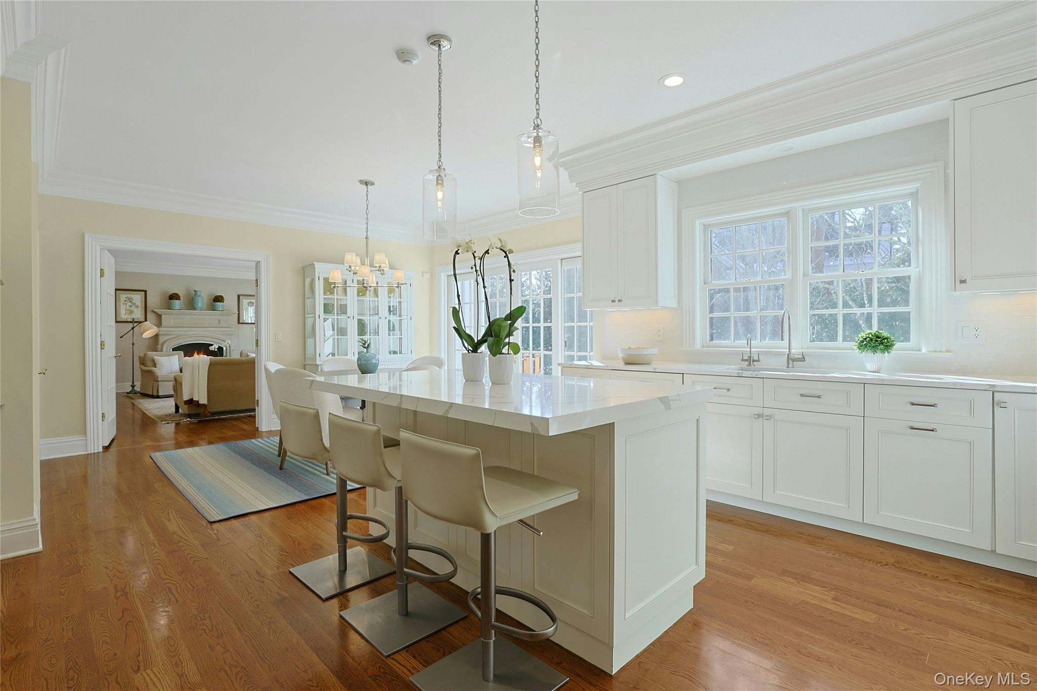 24 Fairview Road Scarsdale, NY 10583 - Photo 10 of 48 Thoughtfully designed for everyday ease, this view highlights the island with seating, large sink with InstaHot and disposal, Bosch dishwasher, and effortless flow between the kitchen, dining area, and family room.