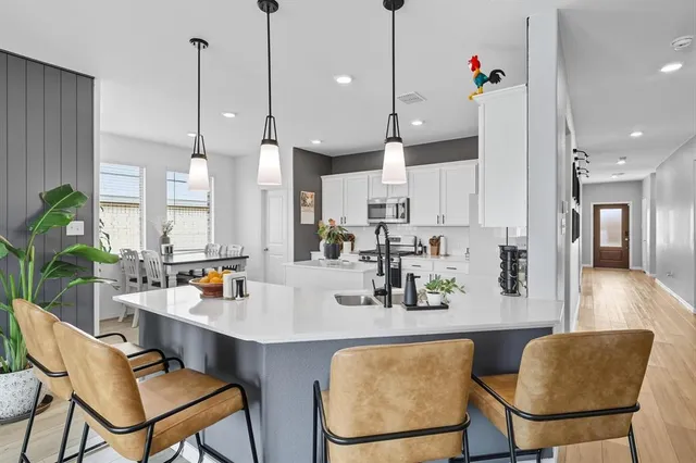a view of a kitchen with kitchen island a sink a center island a living room and a couch
