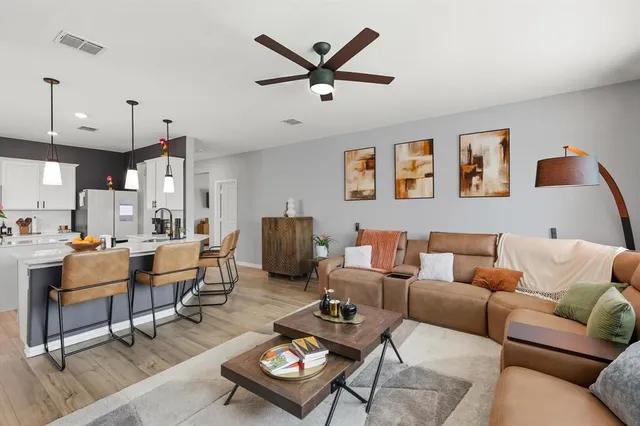 a dining room filled chandelier and kitchen view