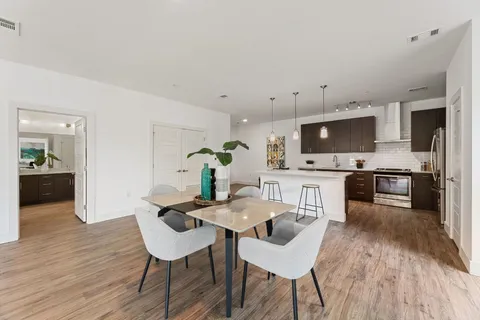 a kitchen with a table chairs microwave and cabinets