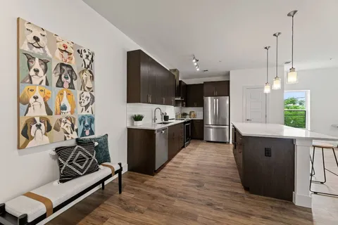 a large white kitchen with a large window and stainless steel appliances