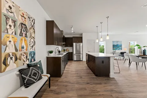 a large white kitchen with a large window and stainless steel appliances