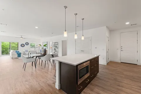 a kitchen with a table chairs refrigerator and wooden floor