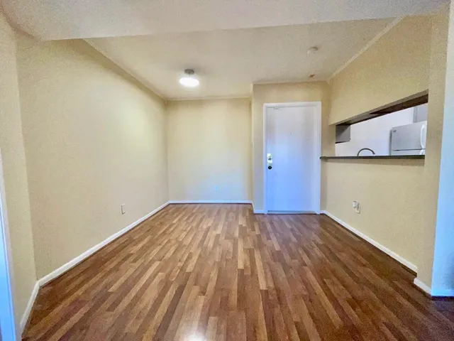 a view of empty room with wooden floor