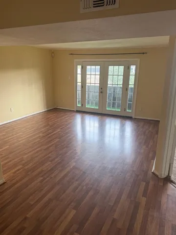 a view of room with wooden floor and fan