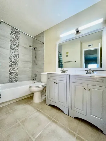 a bathroom with a double vanity sink toilet mirror and bathtub