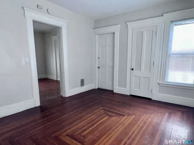 a view of a livingroom with wooden floor and window