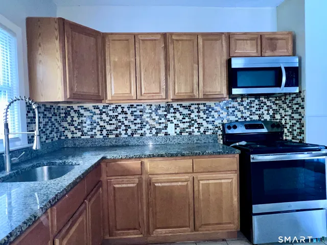 a kitchen with granite countertop a sink and a stove
