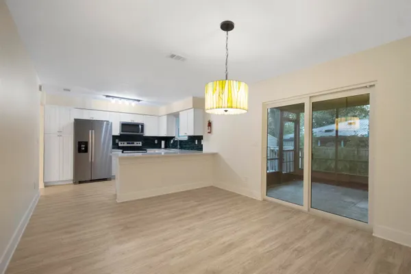 a view of an empty room and kitchen view
