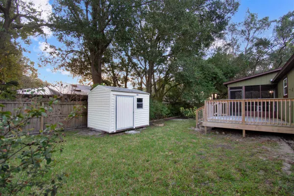 a view of a house with a yard and a large tree