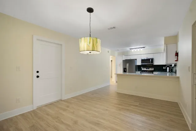 a view of a kitchen with stainless steel appliances granite countertop a refrigerator a stove and a sink
