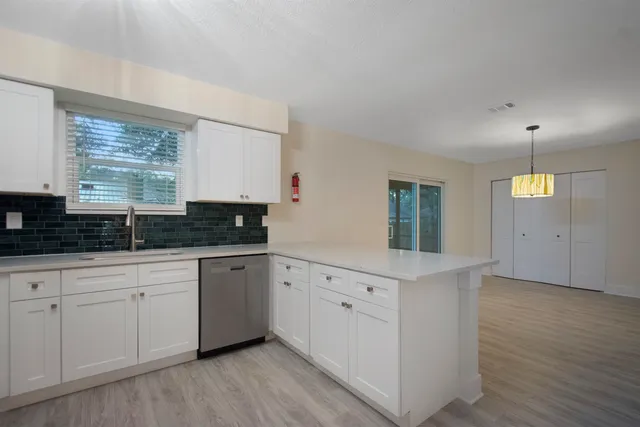 a kitchen with white cabinets and sink