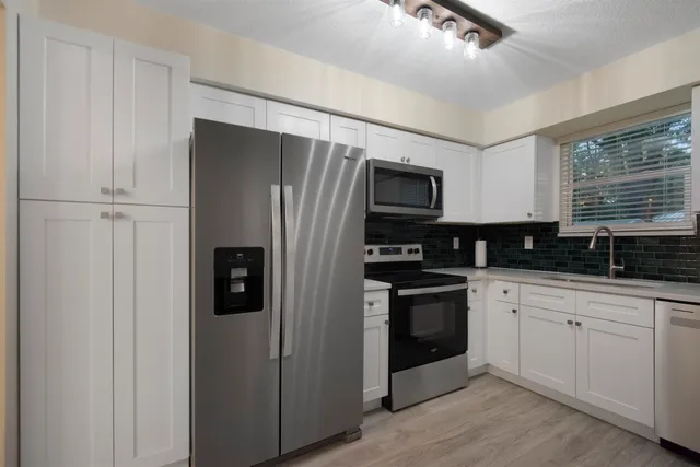 a kitchen with stainless steel appliances a refrigerator sink and stove
