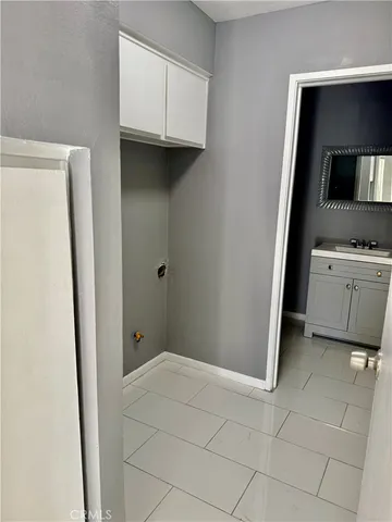 a view of a kitchen with white cabinets and a refrigerator