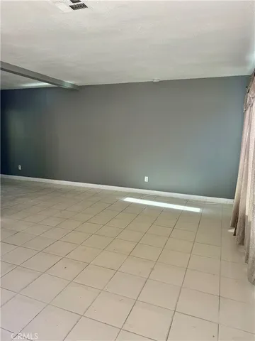 a view of a refrigerator in an empty room