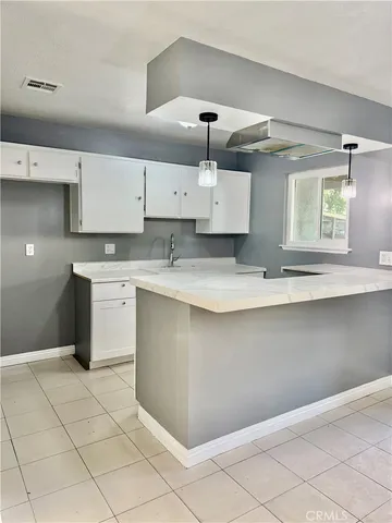a kitchen with a cabinets and chandelier