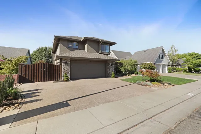 a front view of a house with a yard and potted plants