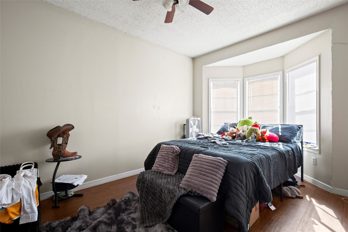 915 West 23rd Street, Unit 208 Austin, TX 78705 - Photo 6 of 16 a bedroom with a bed and wooden floor