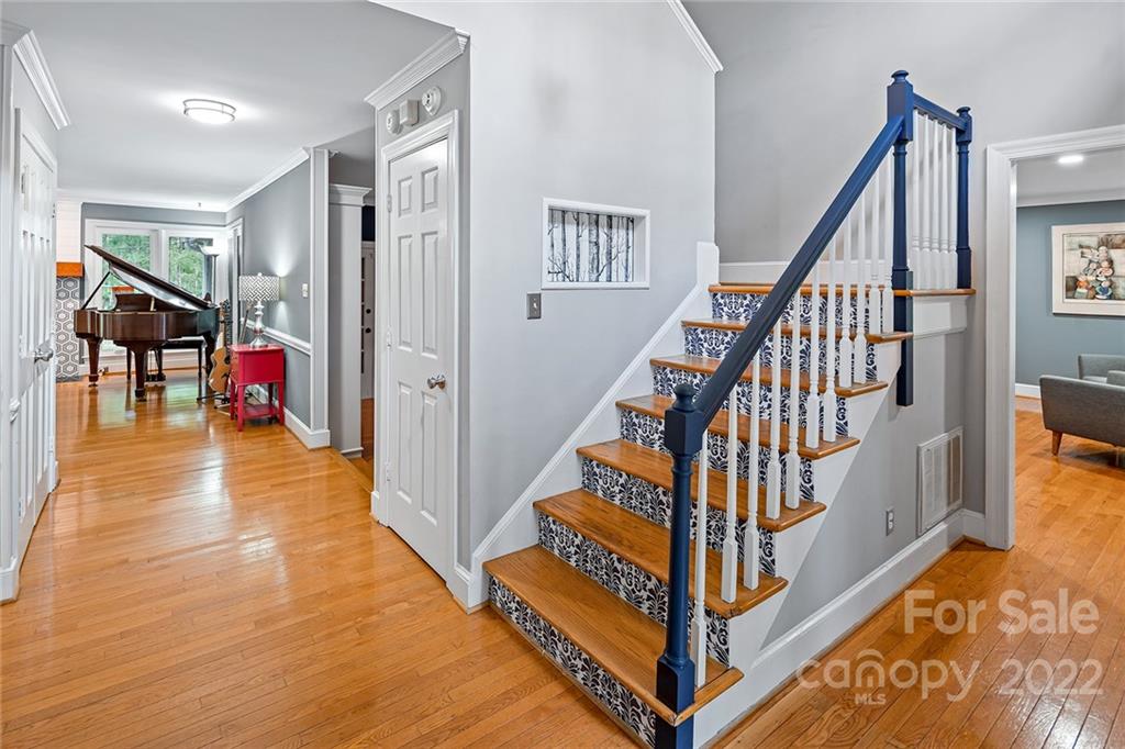 5428 Hillingdon Road Charlotte, NC 28226 - Photo 5 of 36 a view of staircase with lots of frames on wall and a dining table