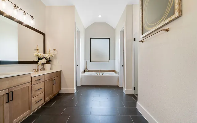 a bathroom with a tub sink and mirror