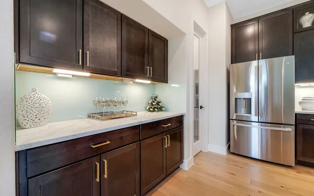a kitchen with stainless steel appliances granite countertop a refrigerator and a sink