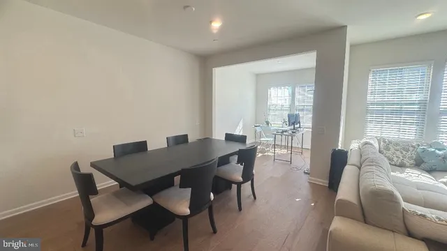 a kitchen with stainless steel appliances kitchen island granite countertop a dining table chairs refrigerator and microwave