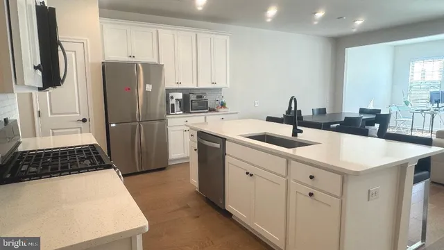 a kitchen with stainless steel appliances a refrigerator sink and cabinets