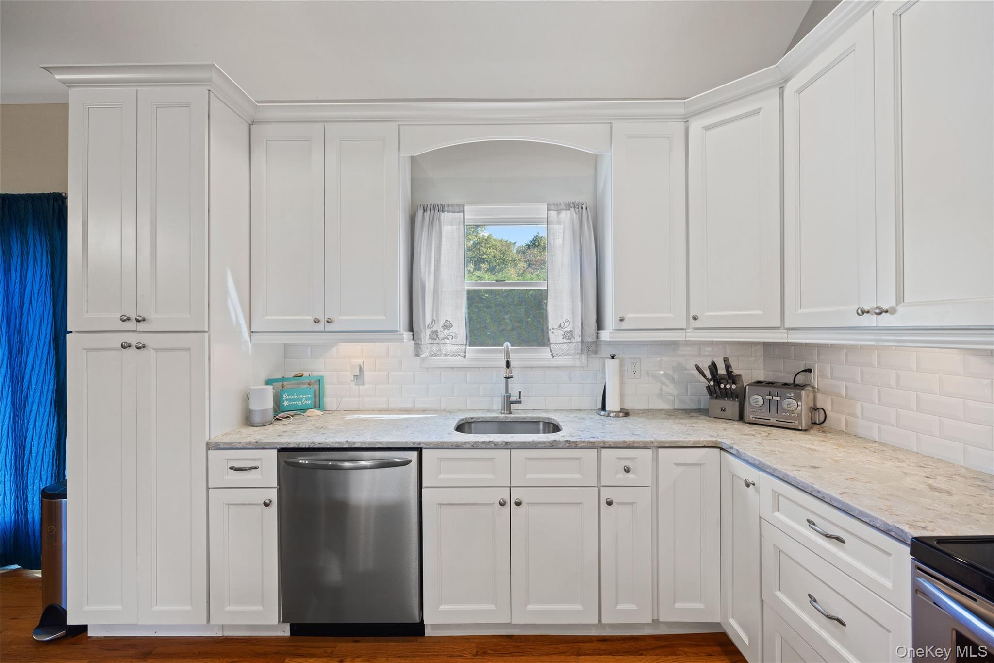 380 Homestead Way Greenport, NY 11944 - Photo 12 of 39 a kitchen with stainless steel appliances granite countertop a sink a stove and cabinets