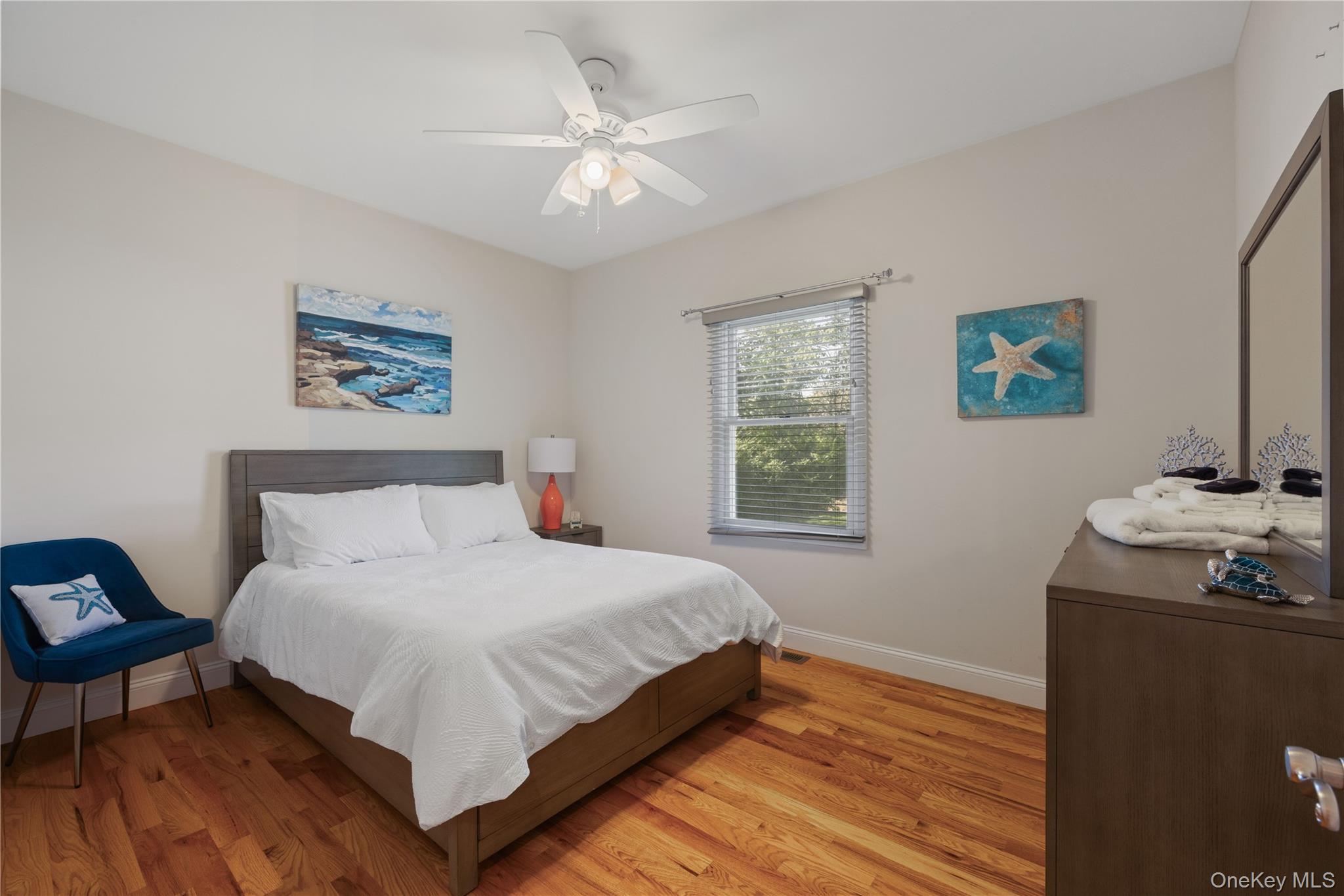 380 Homestead Way Greenport, NY 11944 - Photo 15 of 39 a bedroom with a bed and a chandelier