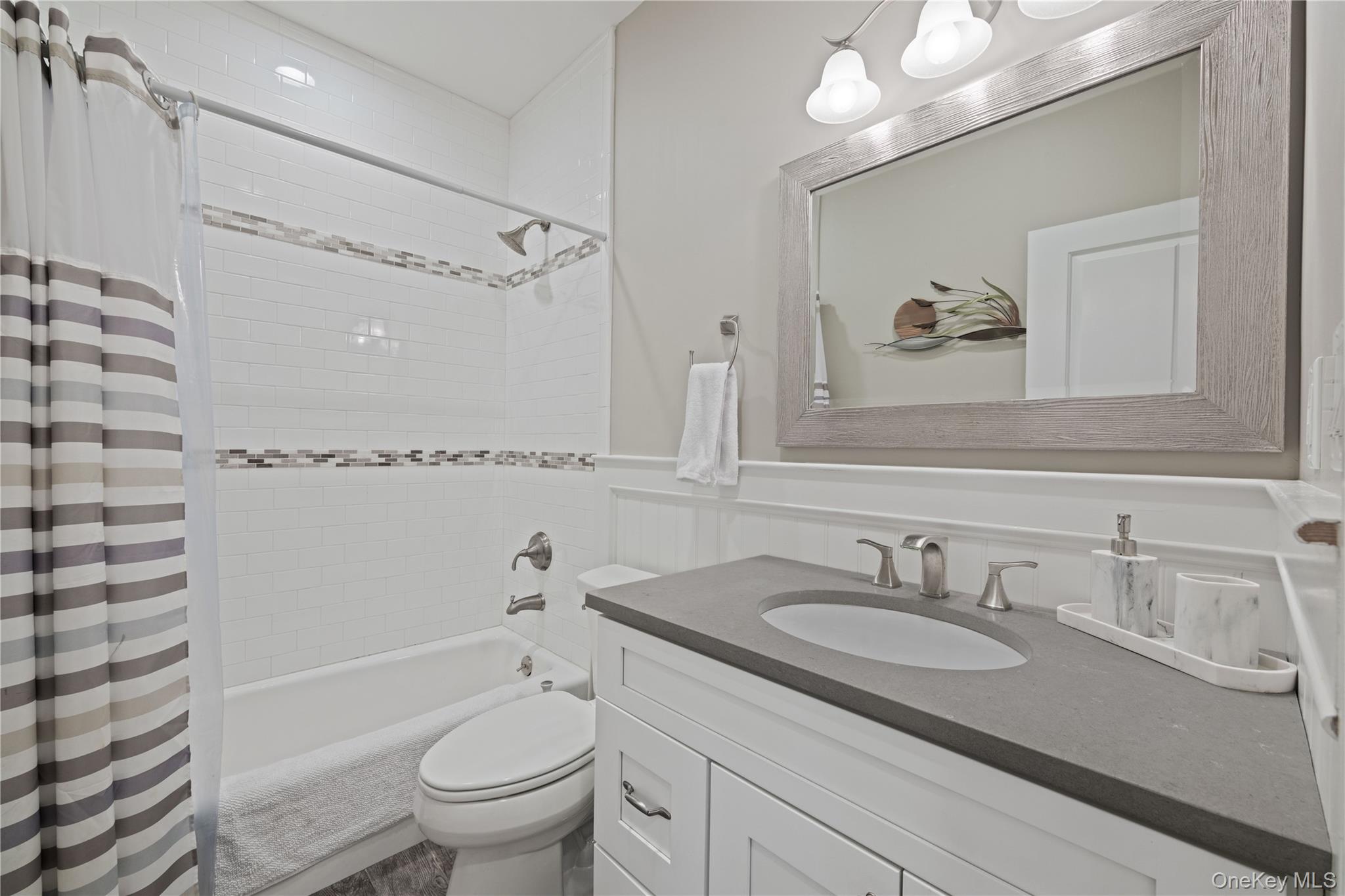 380 Homestead Way Greenport, NY 11944 - Photo 16 of 39 a bathroom with a granite countertop sink a toilet and a mirror