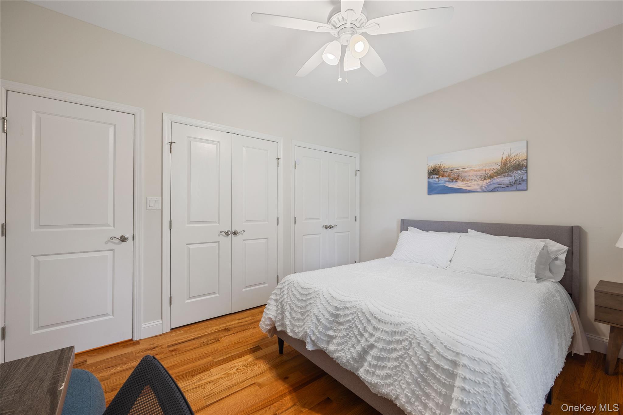 380 Homestead Way Greenport, NY 11944 - Photo 18 of 39 a bedroom with a large bed and a chandelier