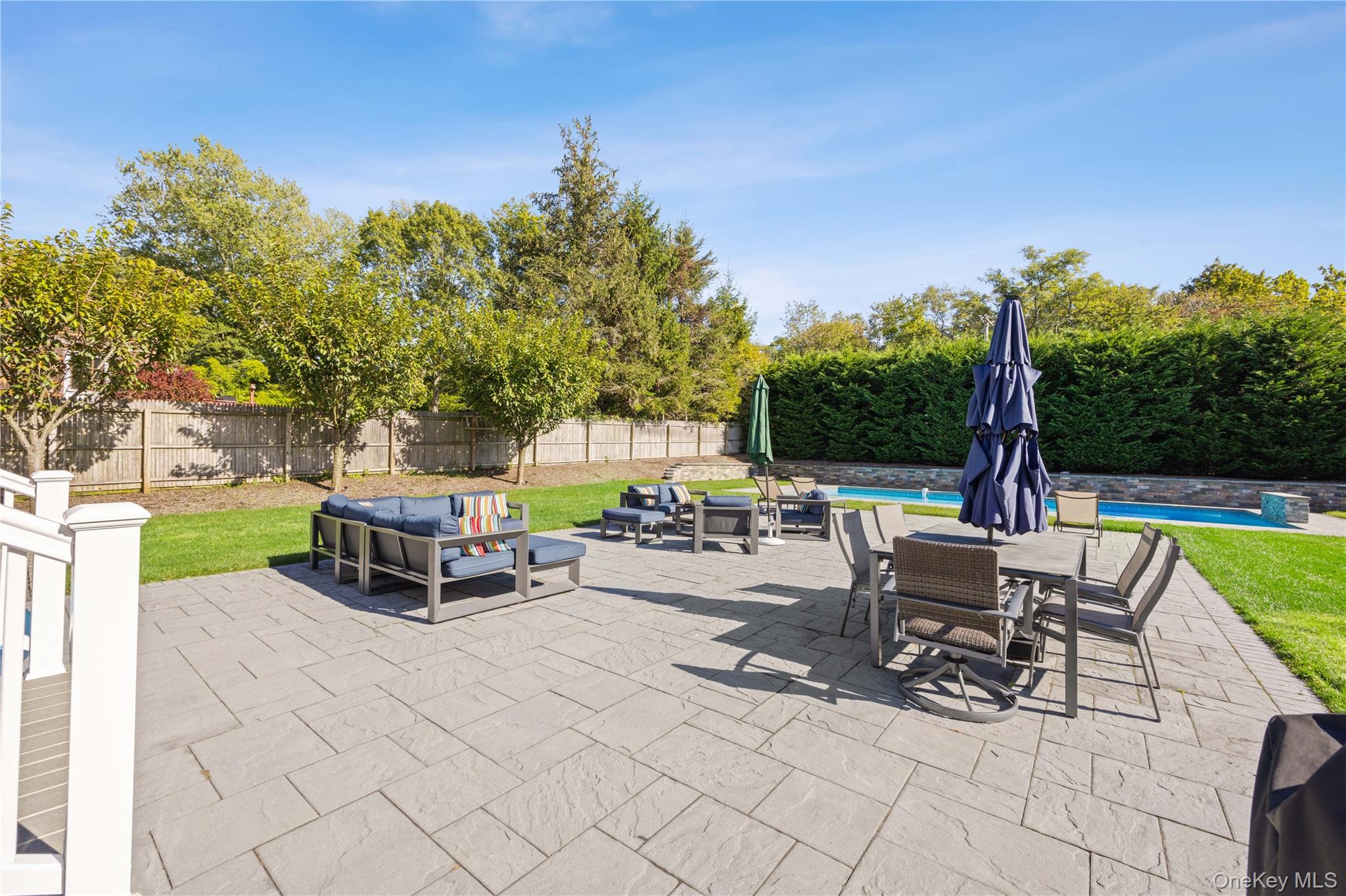 380 Homestead Way Greenport, NY 11944 - Photo 30 of 39 a view of a patio with dining table and chairs with wooden fence