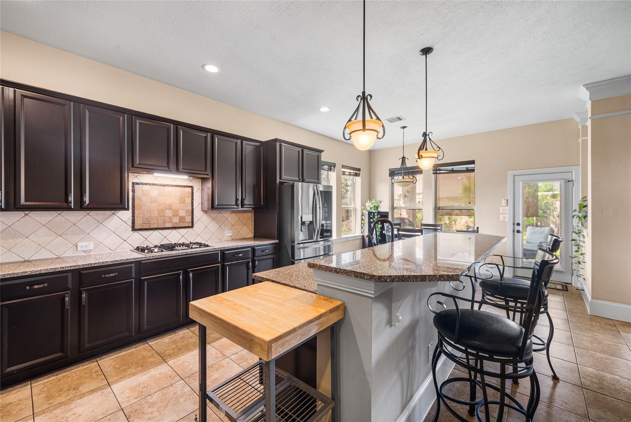 31311 Brighton Brook Lane Spring, TX 77386 - Photo 18 of 47 a kitchen with stainless steel appliances granite countertop a stove a sink a microwave a refrigerator and chairs