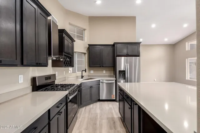 a kitchen with stainless steel appliances a sink stove and refrigerator
