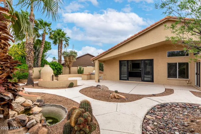 a view of a house with backyard and sitting area