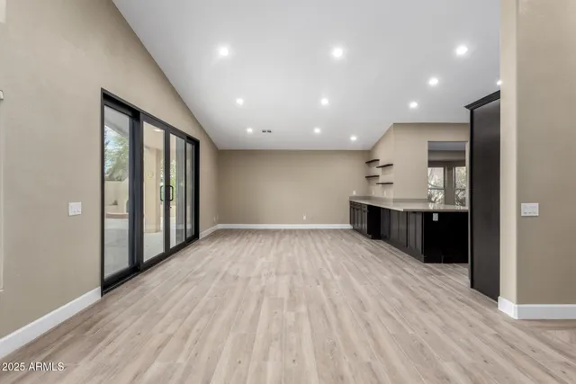 a view of kitchen with stainless steel appliances kitchen island wooden floor large window and a sink