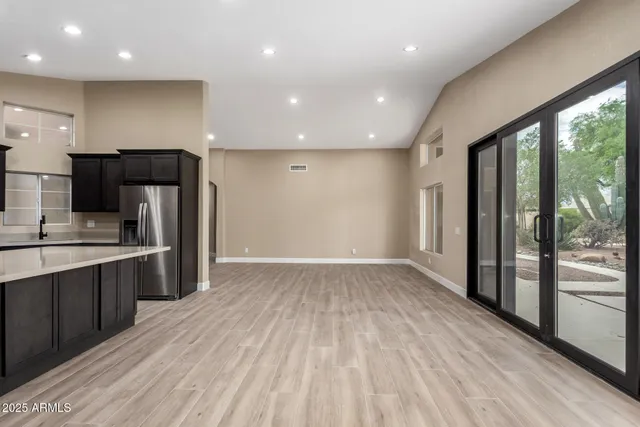 a view of kitchen with stainless steel appliances granite countertop a refrigerator and a sink