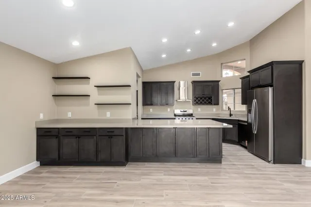 a large kitchen with stainless steel appliances a refrigerator and a sink