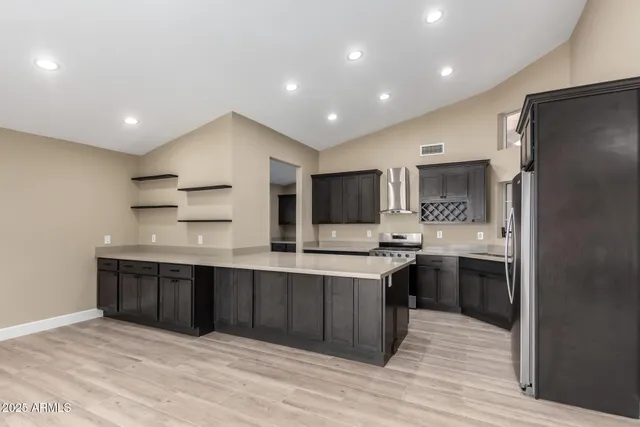 a large kitchen with stainless steel appliances a sink and cabinets