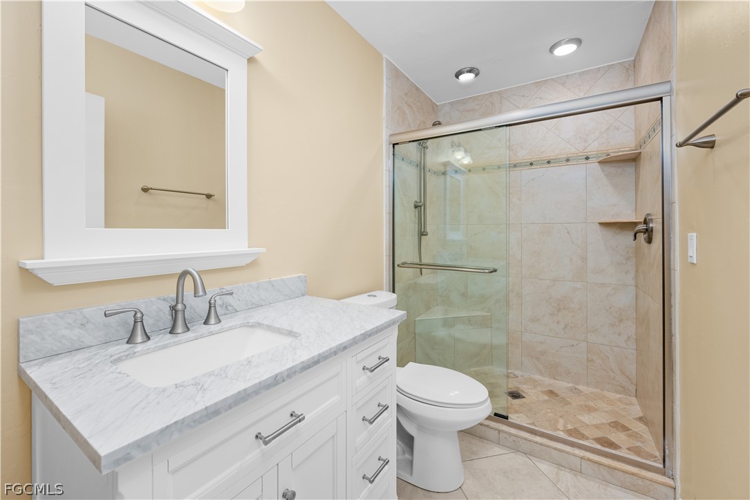 1813 Long Point Lane Sanibel, FL 33957 - Photo 16 of 38 a bathroom with a shower sink vanity mirror and toilet