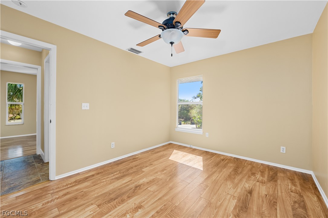1813 Long Point Lane Sanibel, FL 33957 - Photo 17 of 38 an empty room with wooden floor and windows
