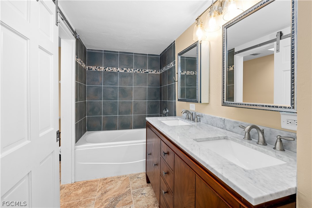 1813 Long Point Lane Sanibel, FL 33957 - Photo 28 of 38 a bathroom with a granite countertop tub sink and mirror