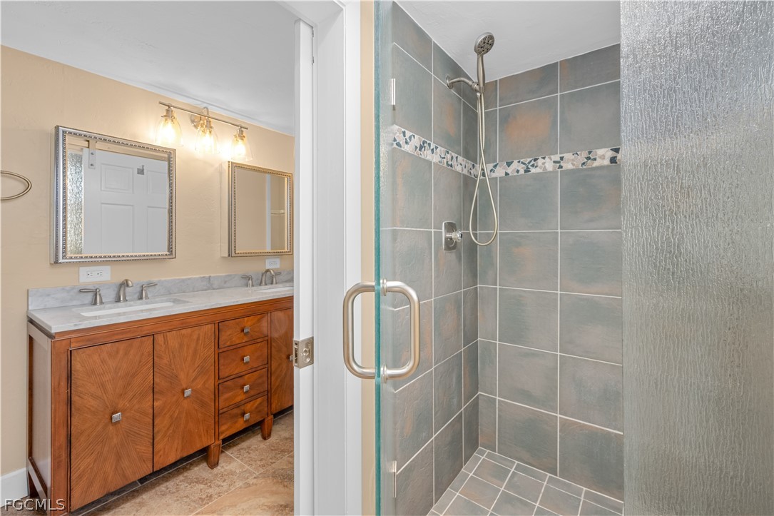 1813 Long Point Lane Sanibel, FL 33957 - Photo 29 of 38 a bathroom with a shower a sink and mirror